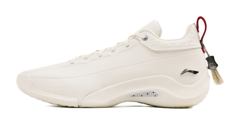 Ivory low-cut basketball shoe with lace-up closure, side S logo and red tag