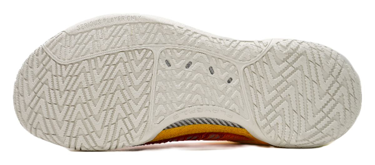 White outsole of multicolor low-top basketball shoes with textured traction pattern