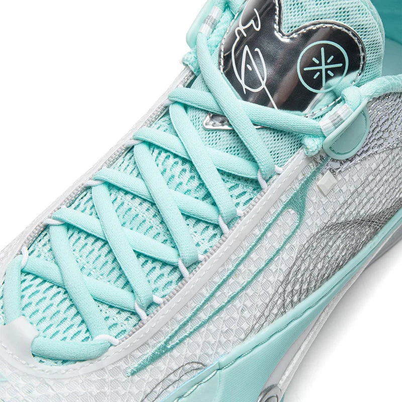Close-up of lace-up basketball shoe showing mint laces and blue-gray textured side panel.
