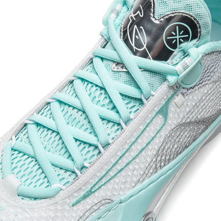 Close-up of lace-up basketball shoe showing mint laces and blue-gray textured side panel.