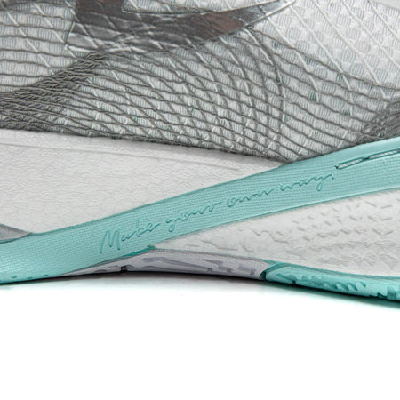 Basketball shoe midsole with teal logo stripe over textured white and gray base