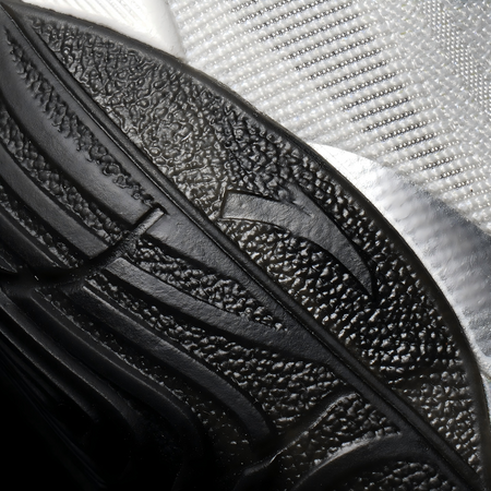 Black basketball shoe insole-side outsole detail with textured tread and curved channels