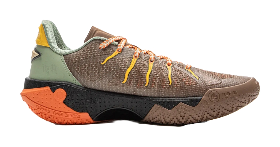 Basketball shoe in brown-beige with green collar, black panel, orange outsole.