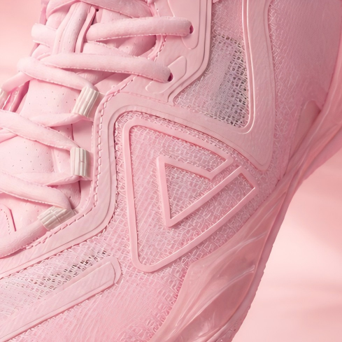Light pink basketball shoe side close-up with molded triangle logo details