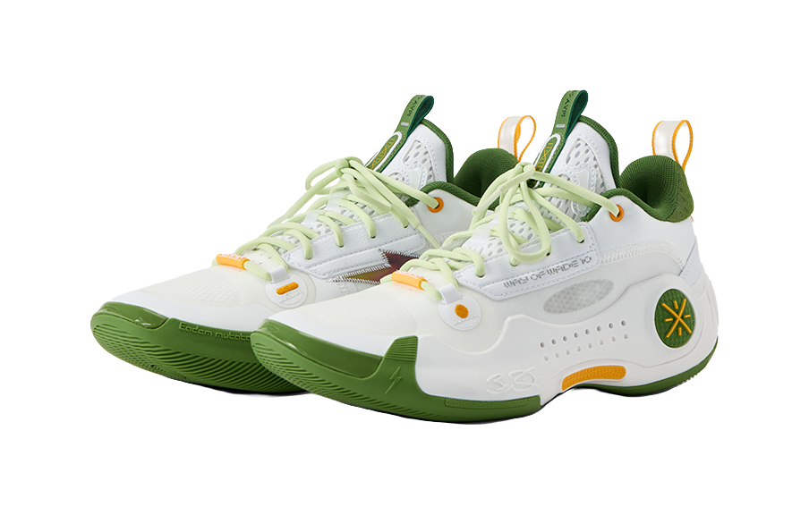 White low-top basketball shoes with green heel collar, light green laces, and orange details.