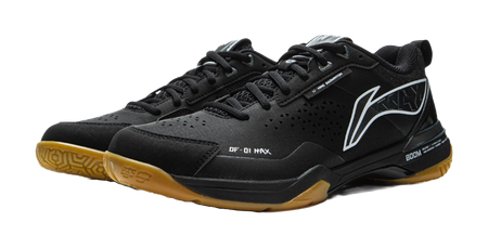 Black badminton shoe with gold outsole edge, black-and-white stripe, and BOOM sole panel.