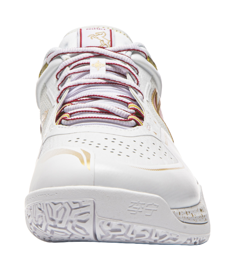 White lace-up badminton shoe front view with red and gold accents