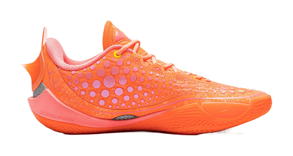 Orange low basketball shoe, side view, dot pattern knit upper and pinkish trim