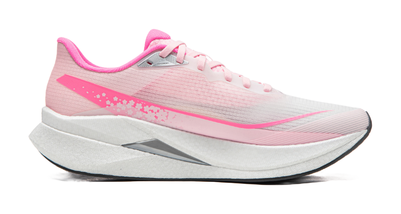 Pink running shoe side view with white laces, gray sole, pink logo and floral accents