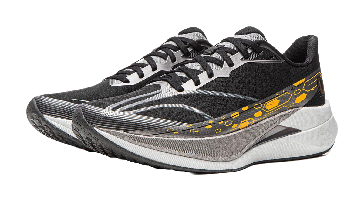 Black running shoe with textured gray panels, white-gray sole and yellow-orange stripe.