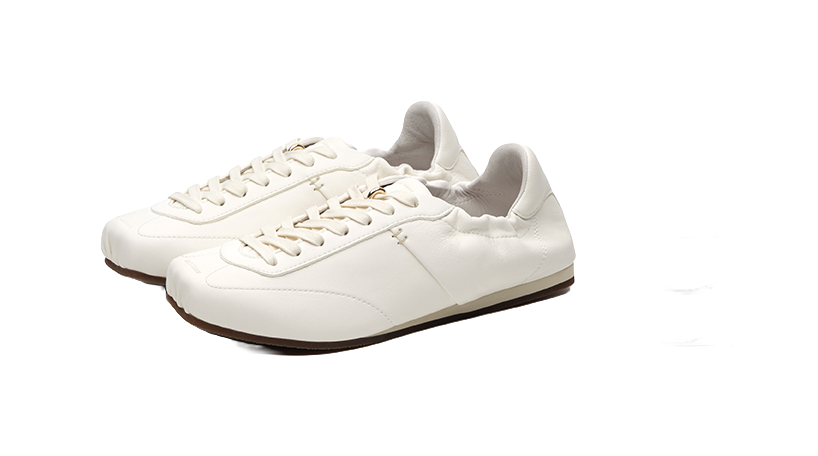 Antique white low-top trainers pair, lace-up front and thin sole with dark edge