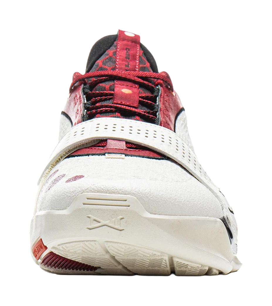 White basketball shoe with red mesh upper, red laces, and textured rubber sole
