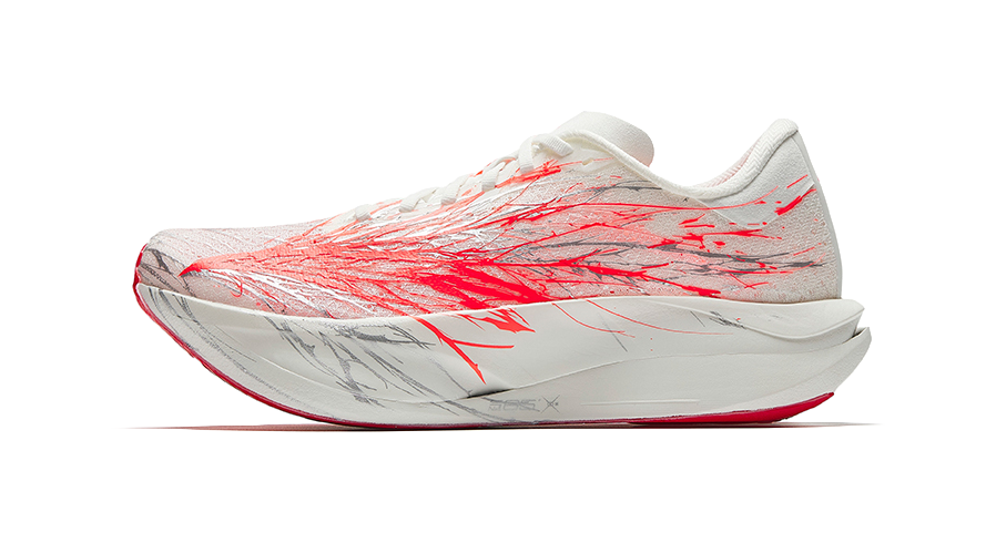 White running shoes with red graphic print, lace-up knit upper, cushioned sole.