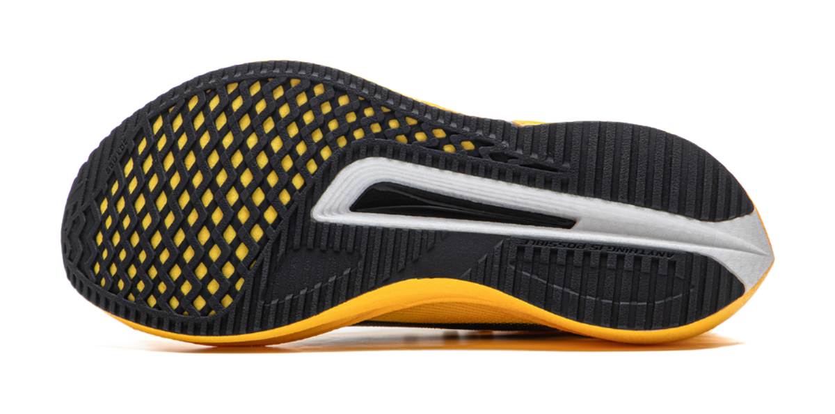 Black and yellow low-top running shoe outsole side view with textured grip pattern.