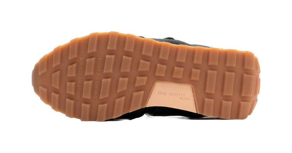Tan rubber outsole of black flat Mary Jane shoes