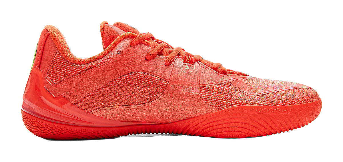 Orange-red low-top basketball shoe, lace-up vamp and textured upper, angled side view.