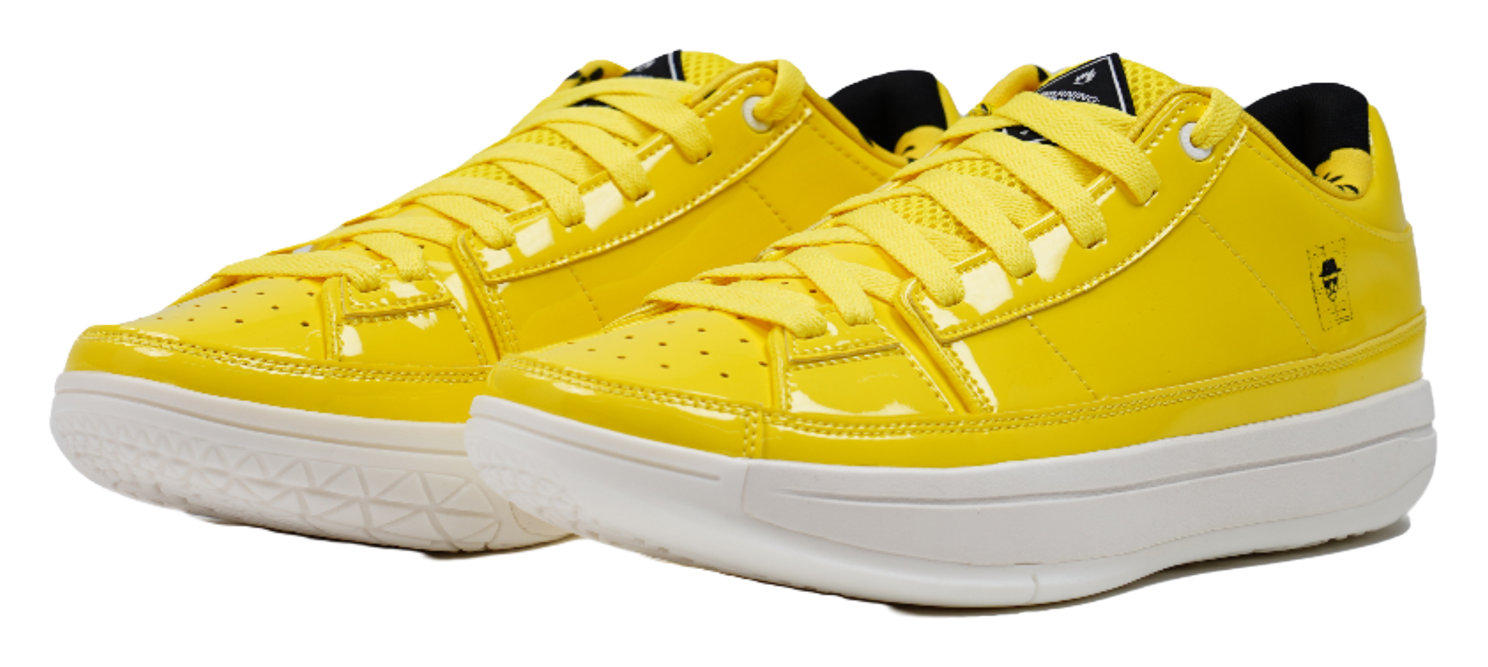 Pair of yellow lace-up basketball shoes with white midsoles and stitched panels