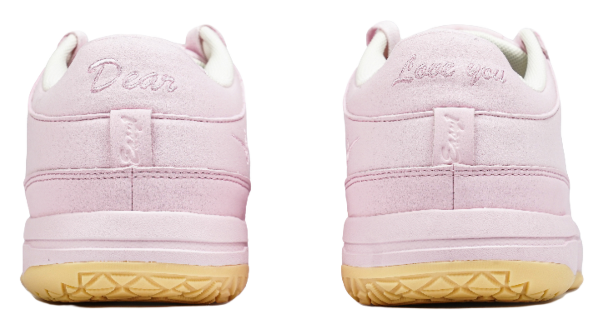Pink low-top sneakers with rear heel branding and cushioned collar