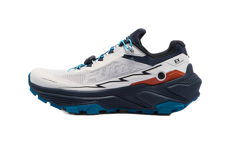 White and navy trail running shoe with blue accents, lace-up closure, side view.