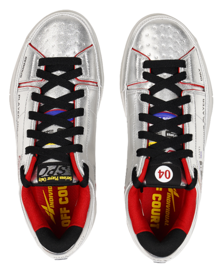 Pair of silver basketball shoes with black laces and red inner lining, top view