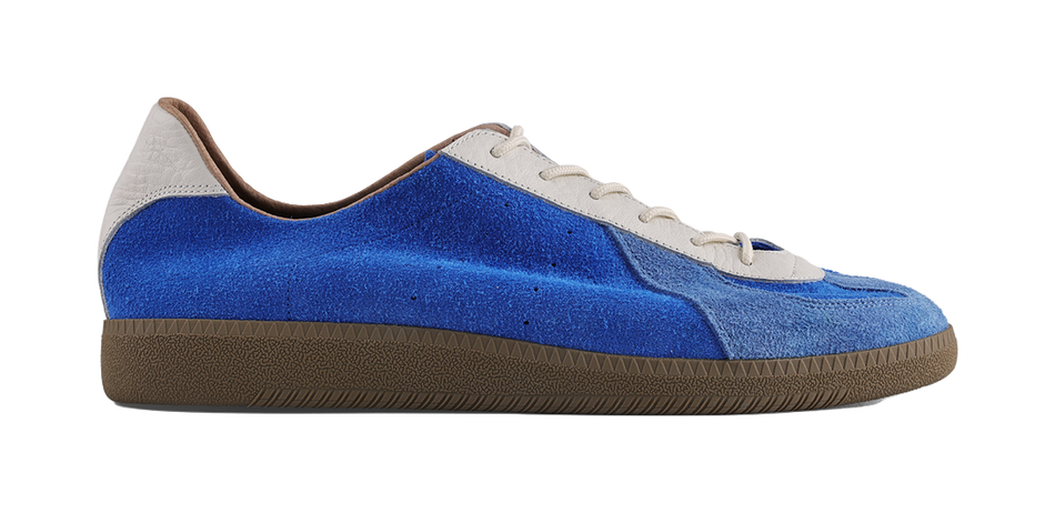 Blue suede low-top sneaker with white laces and brown sole, angled side view.