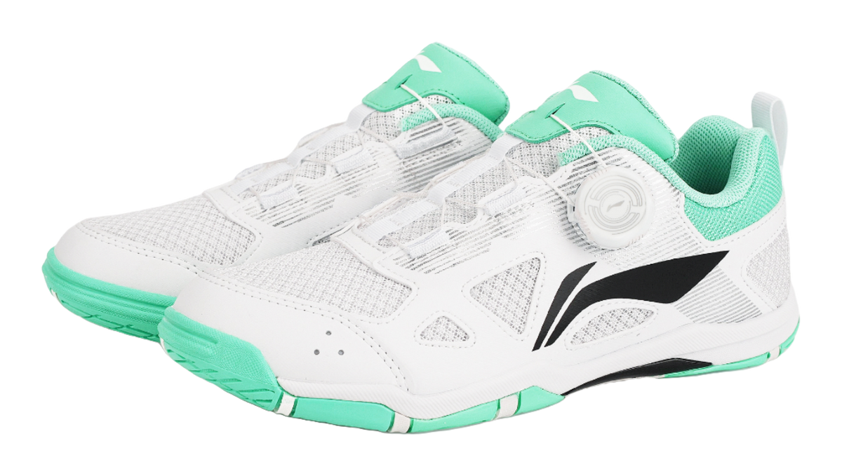 Pair of table tennis shoes in white with green uppers and black side logo