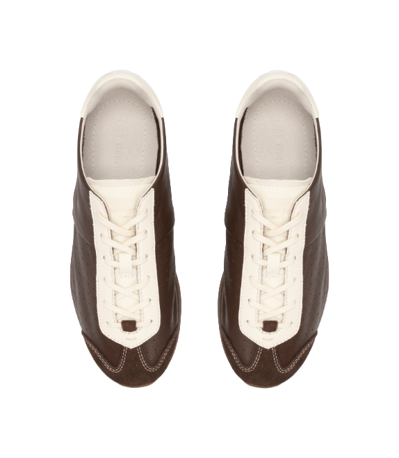 Brown sneakers with antique white laces and uppers, showing stitched toe panel and eyestays.