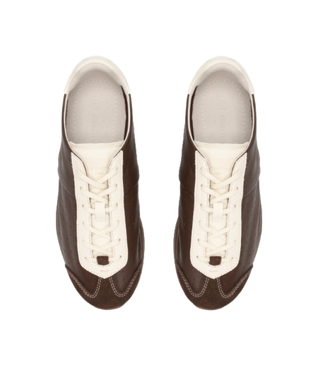 Brown sneakers with antique white laces and uppers, showing stitched toe panel and eyestays.