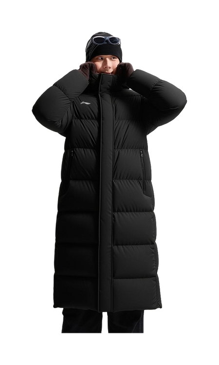 Black hooded long puffer down jacket on model with zip front and raised hood for warmth.