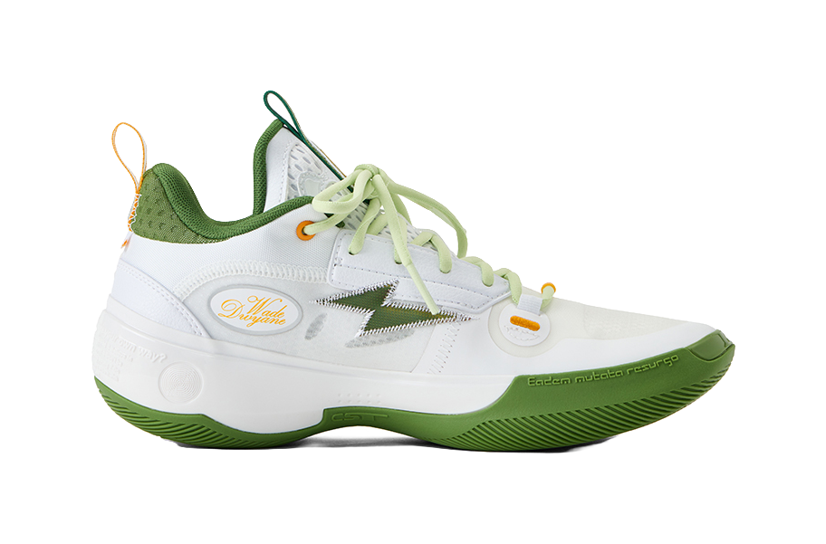 White low-top basketball shoes with green panels, light green laces, and orange accents.