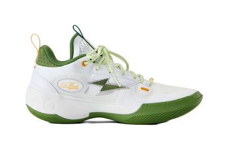 White low-top basketball shoes with green panels, light green laces, and orange accents.