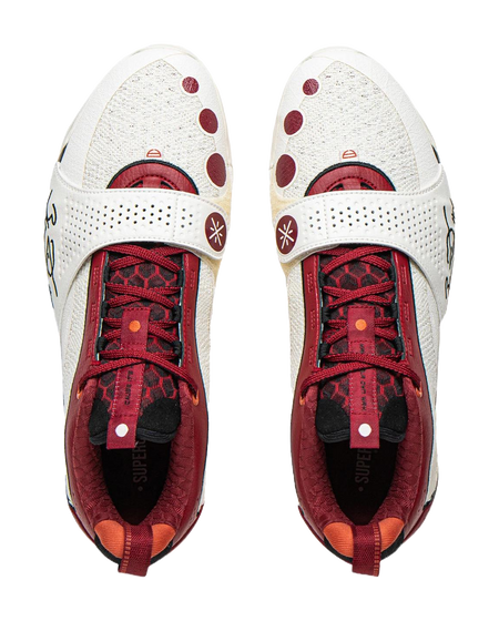Pair of white basketball shoes with red laces, red patterned lining, and cushioned tongues