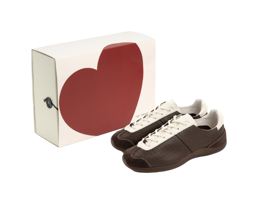 Brown and antique white low-top sneakers with lace-up closure and perforated side panels.
