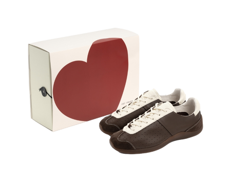 Brown and antique white low-top sneakers with lace-up closure and perforated side panels.