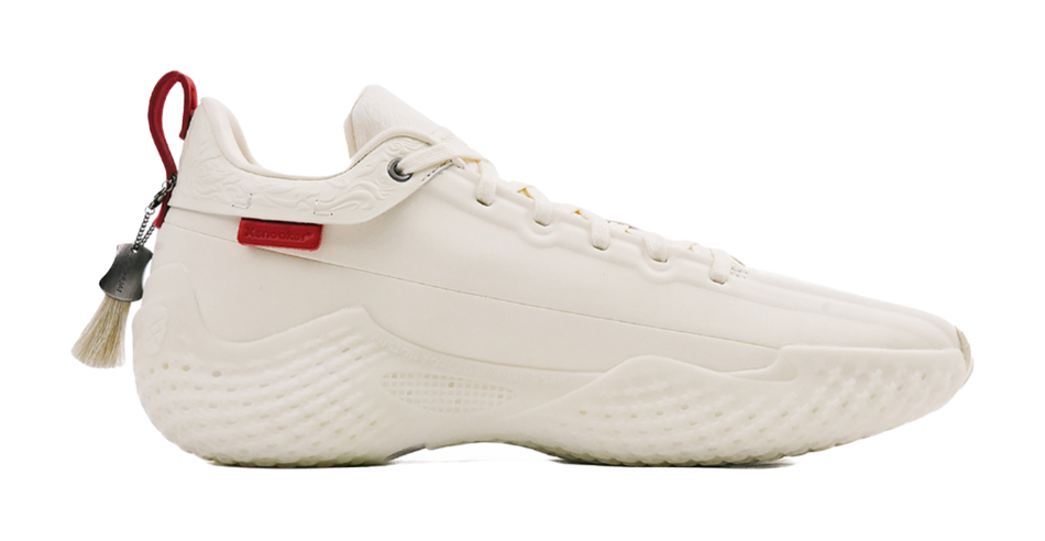 Ivory low-cut basketball shoe with lace-up closure, molded midsole and red heel pull
