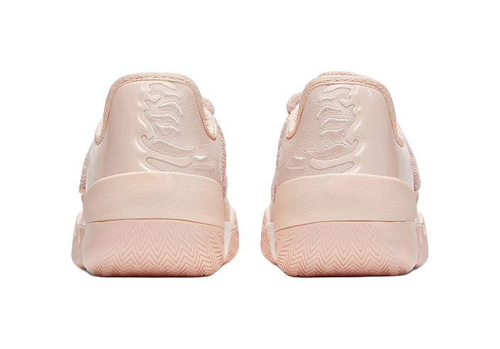 Soft pink low basketball shoes, rear view with molded heel panel and zigzag outsole