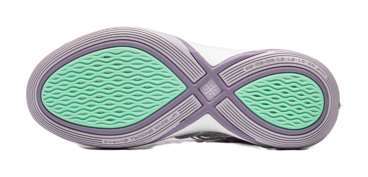 Lavender outsole of low basketball shoe with green tread and cross-strap pattern