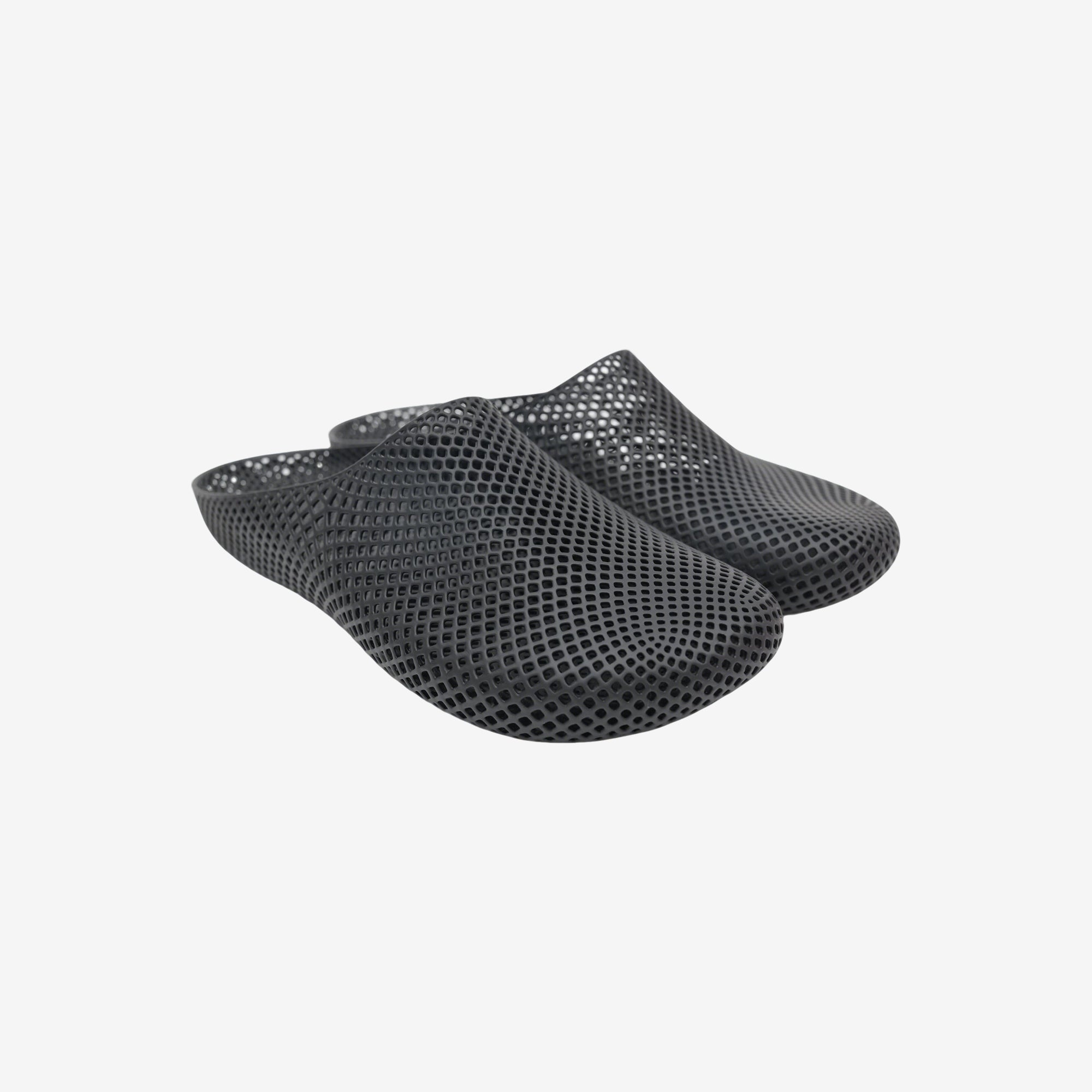 Black 3D printed slippers with open slip-on design and textured mesh surface