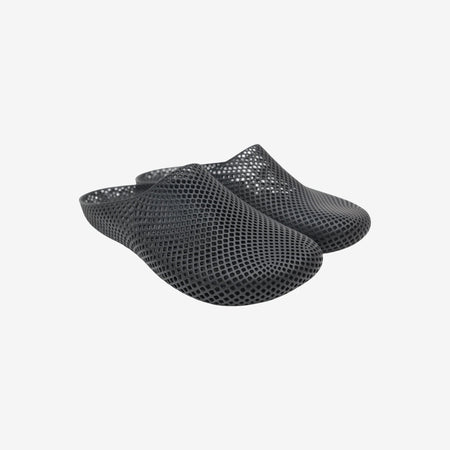 Black 3D printed slippers with open slip-on design and textured mesh surface