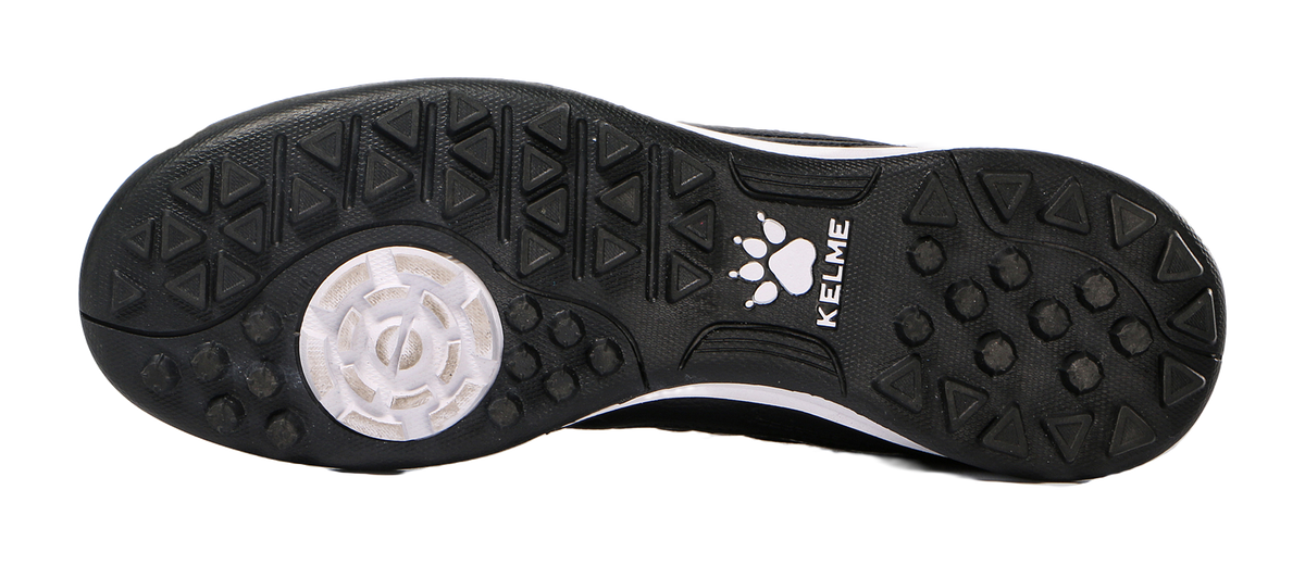 Black TF training soccer shoe outsole with molded studs and paw logo