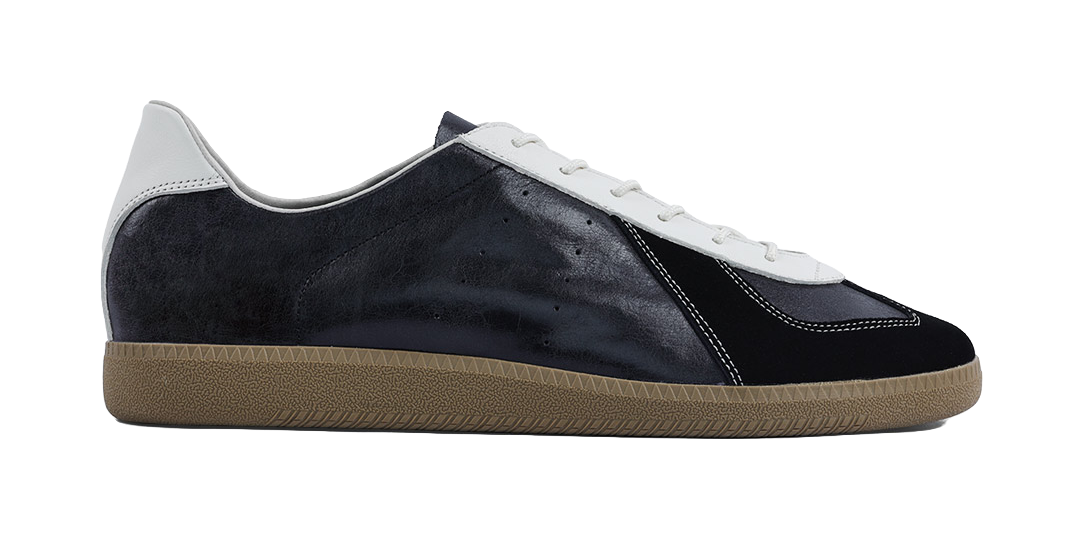 Side view of dark low-top training shoes with white laces and gum sole