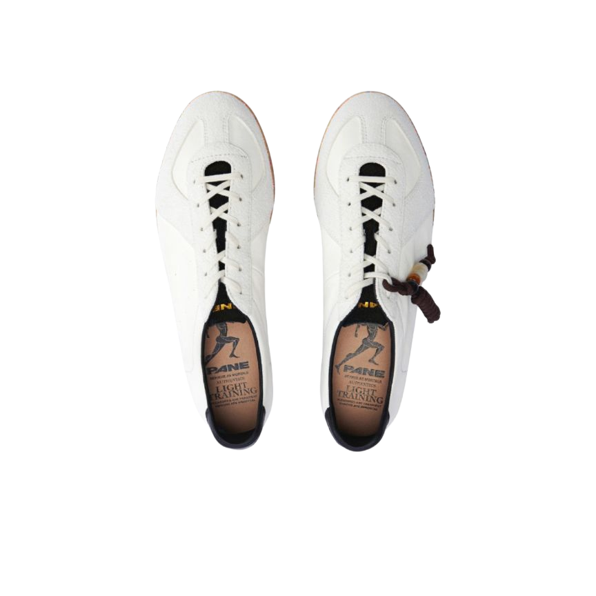 White low-top training sneakers pair with black laces and side logo