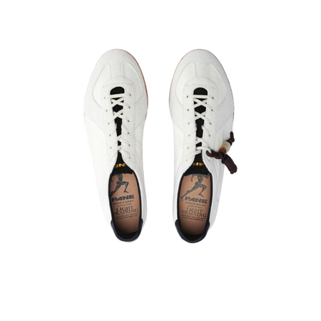 White low-top training sneakers pair with black laces and side logo