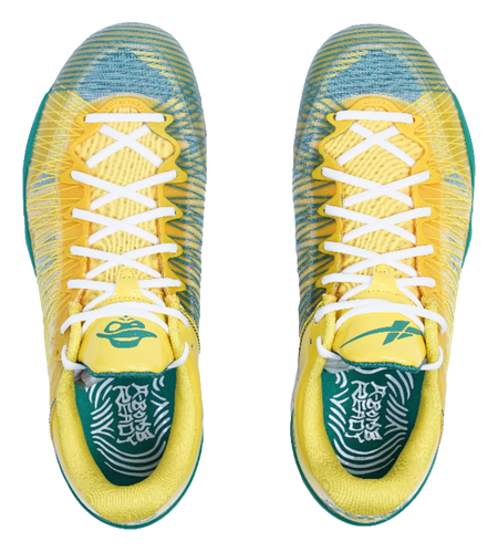 Front view of yellow sneakers with white crisscross laces and green patterned lining