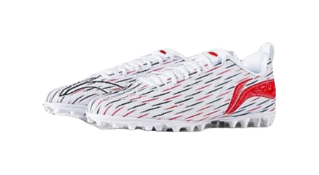 Youth soccer shoe side profile: white upper with red accents and black pattern lines
