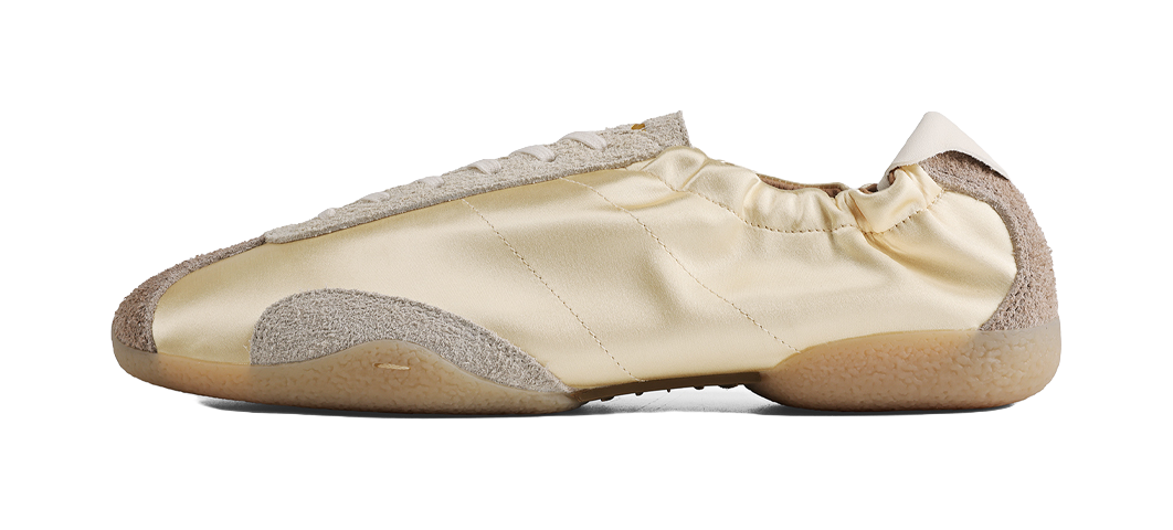 Light yellow low-top ballet training shoe with thin sole and gray toe cap