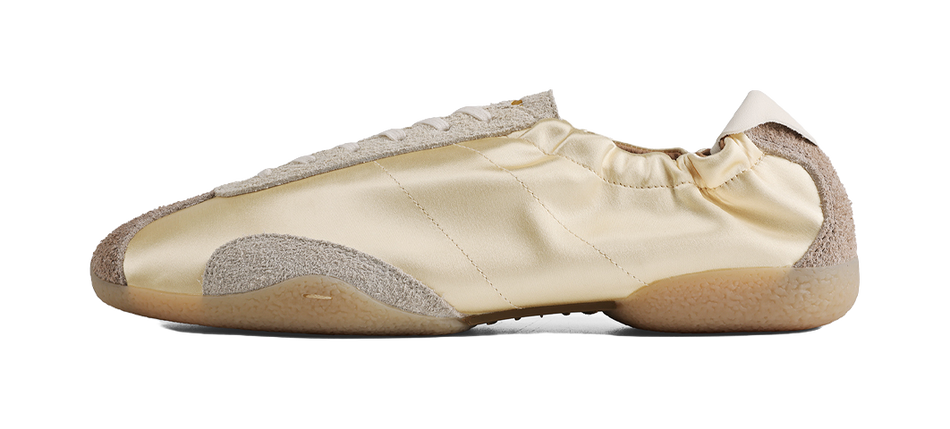 Light yellow low-top ballet training shoe with thin sole and gray toe cap