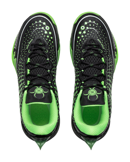 Pair of black and neon green low basketball shoes with lace-up front and graphic details