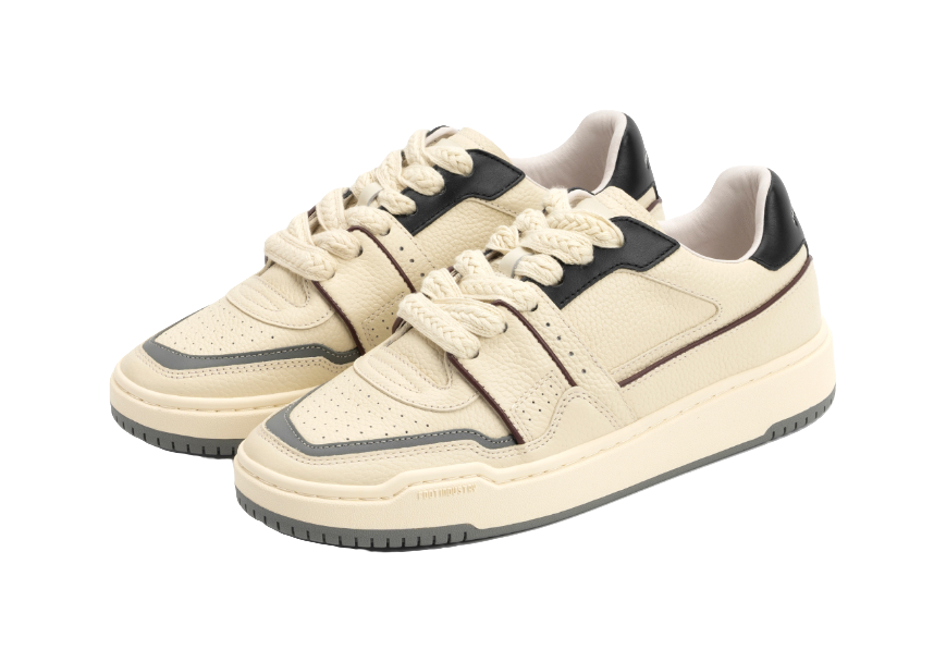 Pair of ecru low-top skate shoes with black details and white lace-up design