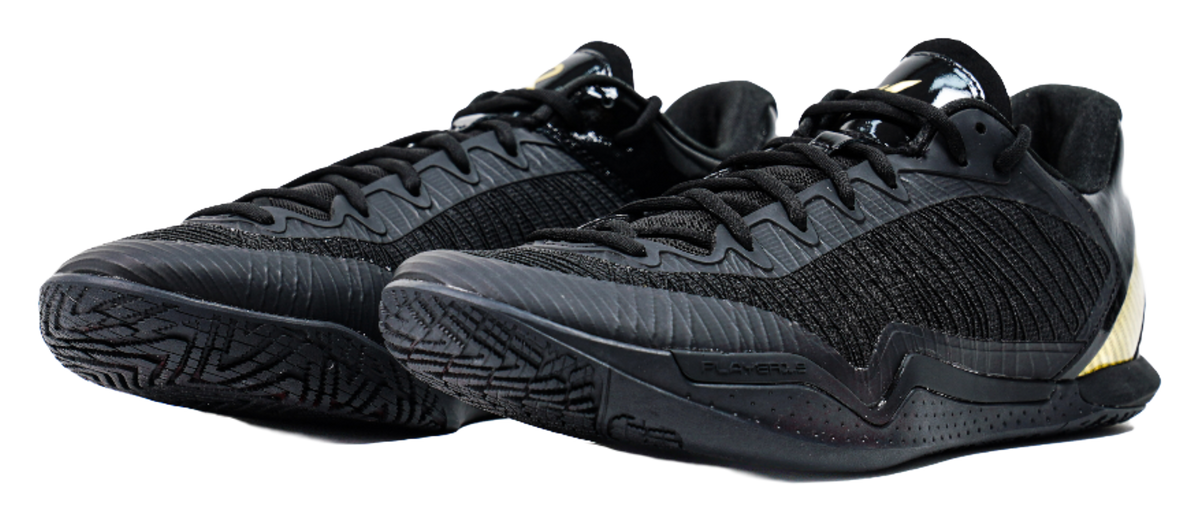 Black low-cut lace-up basketball shoe with textured knit upper and detailed outsole